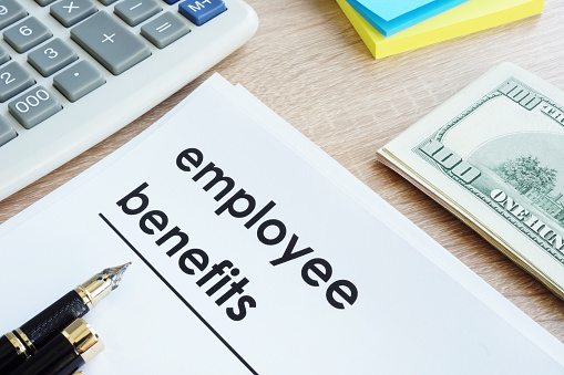 Document with title employee benefits on a desk.